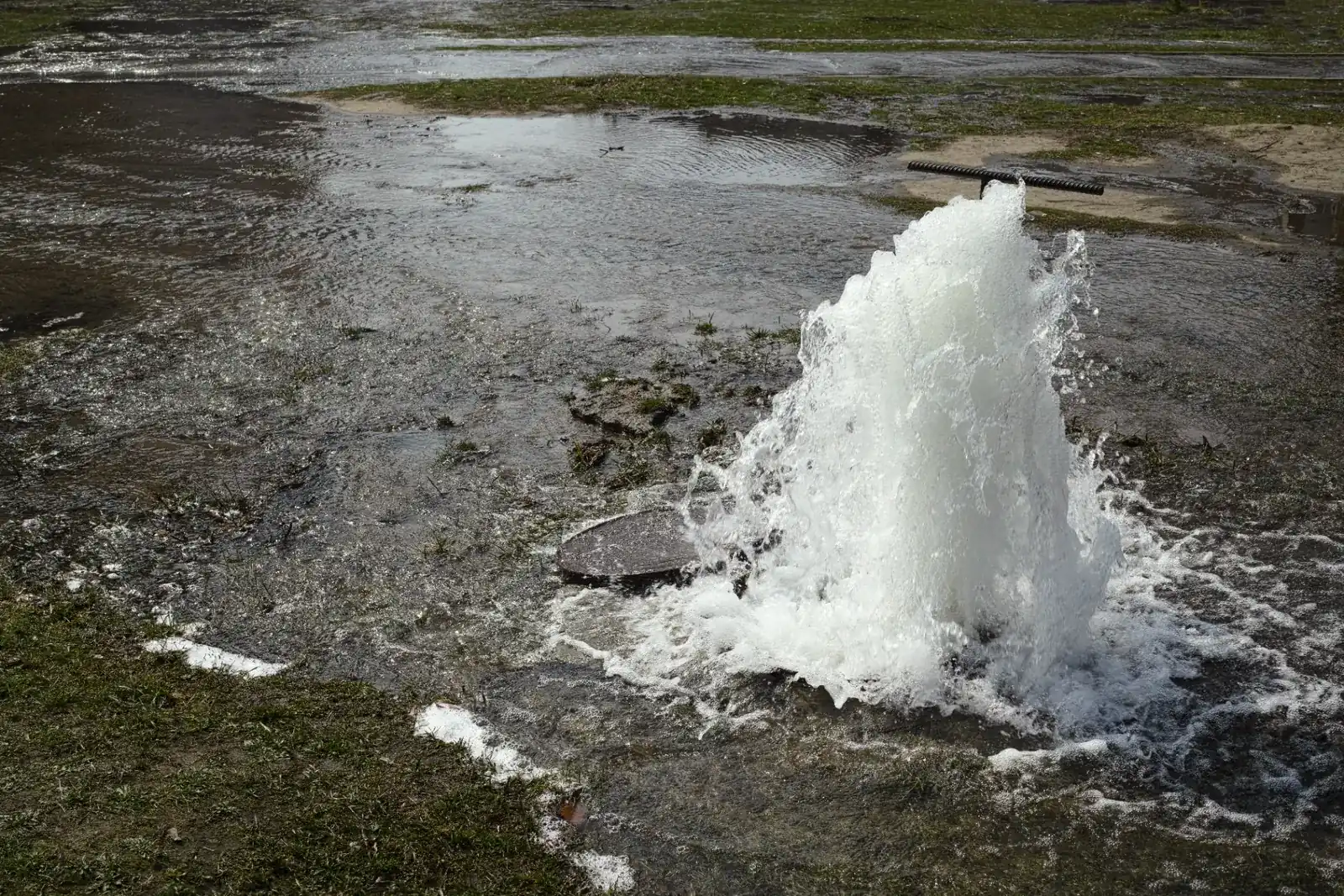 Water gushing from a manhole during an emergency overflow event.
